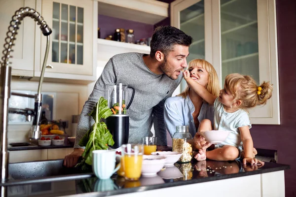 Girl feeding her father in kitchen — Stock Photo, Image