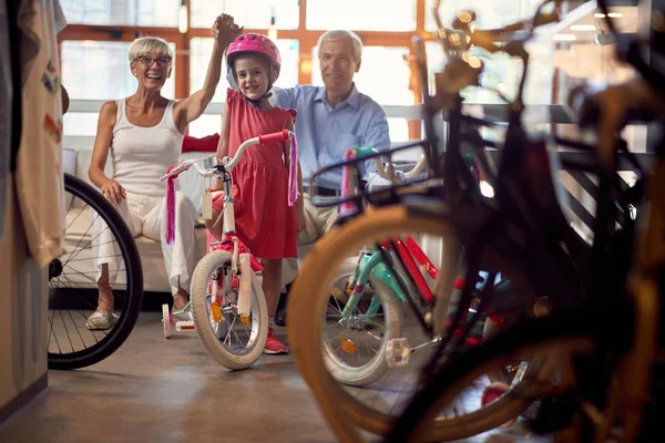 Бабусі і дідусі купують новий велосипед для маленького пояса — стокове фото
