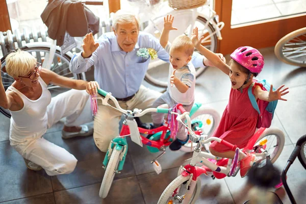 孫と一緒に新しい bicycl を購入する幸せなシニアファミリー — ストック写真
