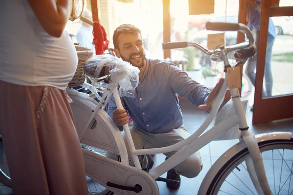 Hombre vendedor está ayudando a la mujer a elegir nueva bicicleta en bicicleta sho —  Fotos de Stock