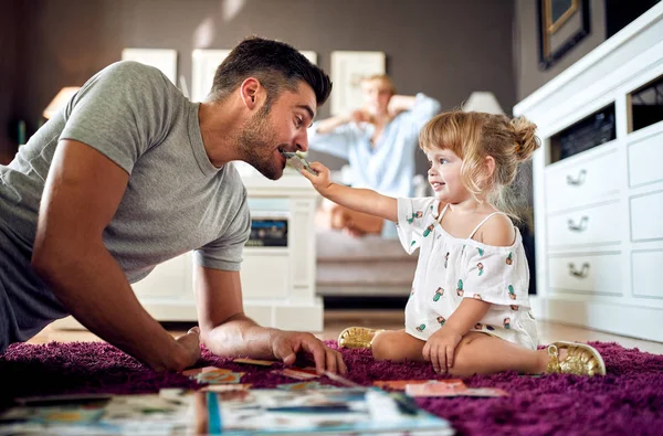 Dochter zetten puzzel in vaders mond — Stockfoto