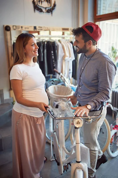 Uomo venditore sta aiutando donna sorridente per l'acquisto di nuove biciclette nel negozio di biciclette — Foto Stock