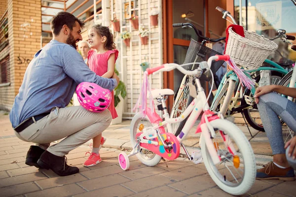 Happy father buys smiling daughter new bicycle in shop — Stock Photo, Image