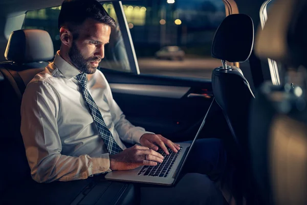 Hombre de negocios cansado trabajando hasta tarde en el coche en el ordenador portátil — Foto de Stock