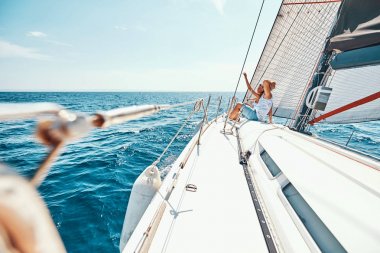 Genç çift gemi güvertesinde manzaranın keyfini çıkarıyor.