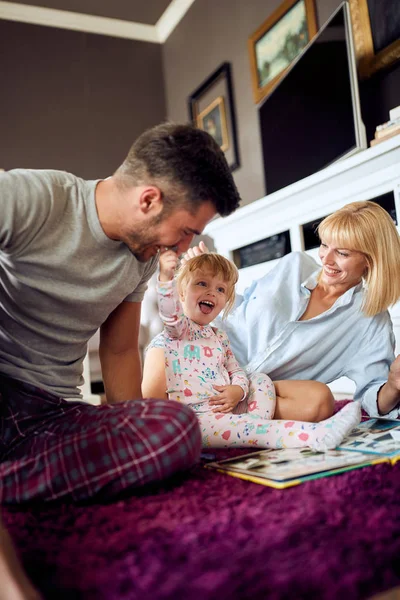 Usměvavá rodina se baví s roztomilým dítětem — Stock fotografie