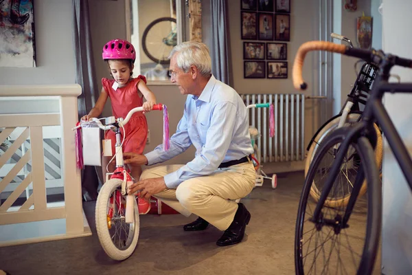Abuelo sonriente y niño eligiendo bicicleta en la tienda de bicicletas —  Fotos de Stock