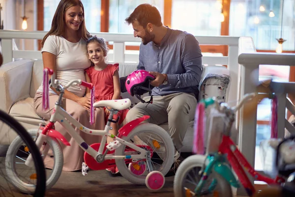 Ojciec i matka kupują nowy rower dla małego dziecka w sklepie rowerowym — Zdjęcie stockowe