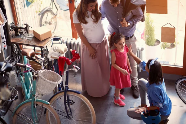 Verkoop fiets-verkoper vrouw om jonge familie nieuwe fiets te verkopen — Stockfoto