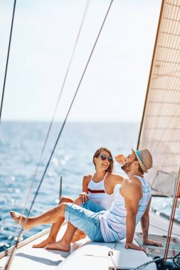 Gülümseyen çift birlikte vakit geçiriyor ve yatta dinleniyor