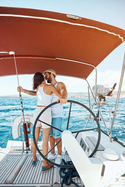 Beautiful man and woman of lovers sailing on a boat