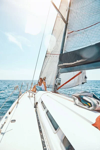 Unga par spenderar lycklig tid på en yacht till sjöss — Stockfoto