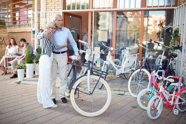 Casal de idosos escolhendo nova bicicleta na loja de bicicletas — Fotografia de Stock