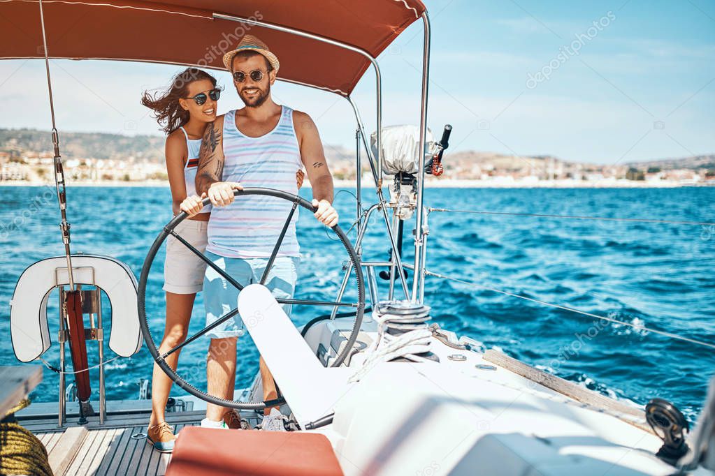 Young couple on a sailing boat -Romantic vacation and luxury travel