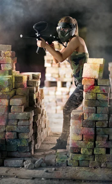 Paintball player with gun in action — Stock Photo, Image