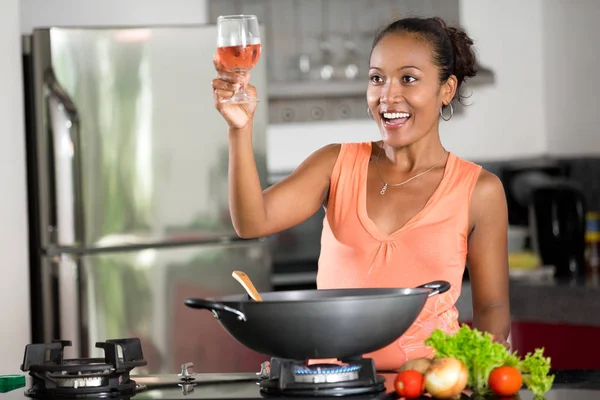 Ung hemmafru matlagning och en skål för gästerna — Stockfoto