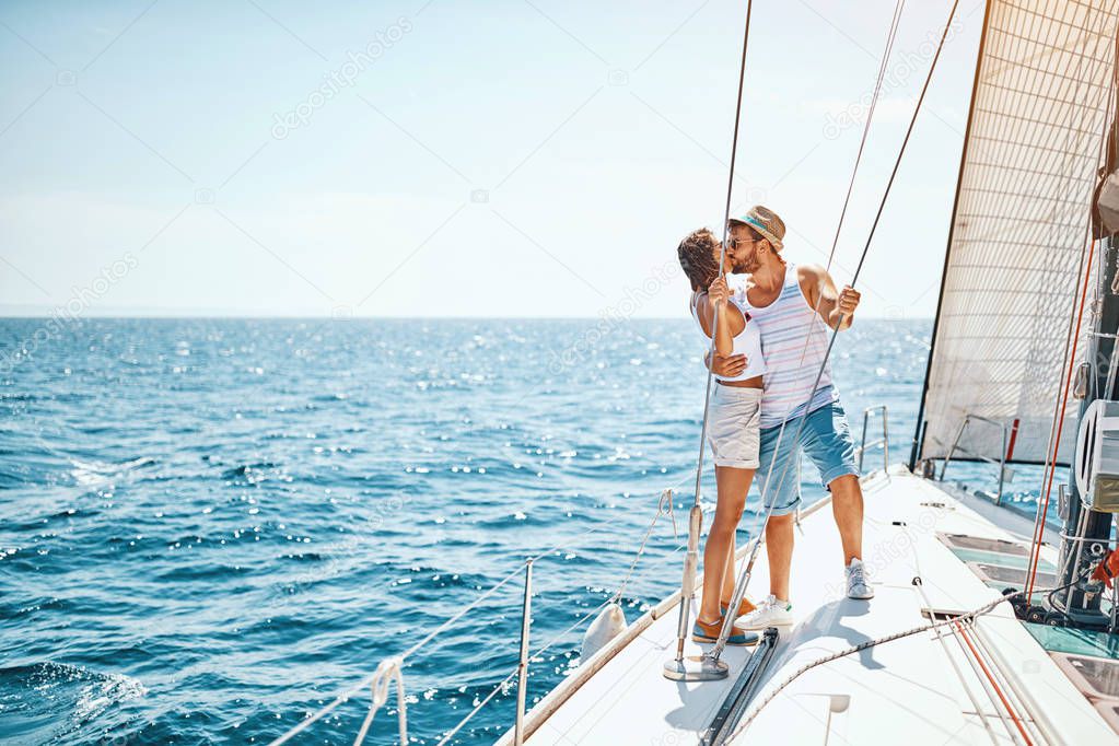 Man and woman in love on a sail boat in the summe