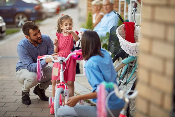 Vendedor mujer ayudando a la familia a comprar nueva bicicleta para niña —  Fotos de Stock