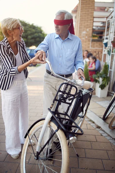 Seniorin verdeckt Augen eines älteren Mannes für Überraschung beim Kauf — Stockfoto