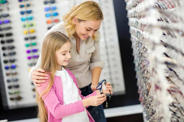 Moeder helpen haar meisje om te kiezen goede frame voor bril — Stockfoto