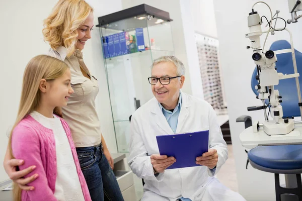 Older eye specialist finished eye examination of child