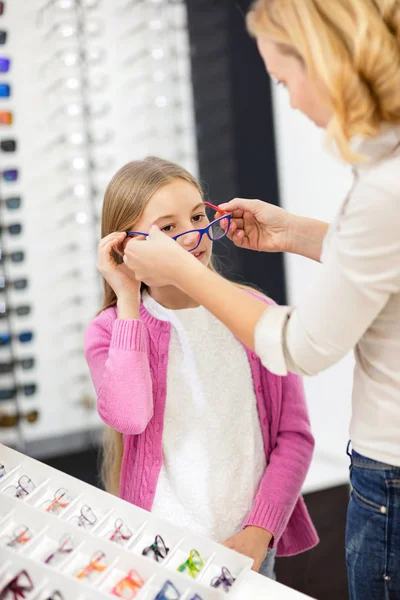 Mamma hjälpa sin dotter att välja ram glasögon — Stockfoto