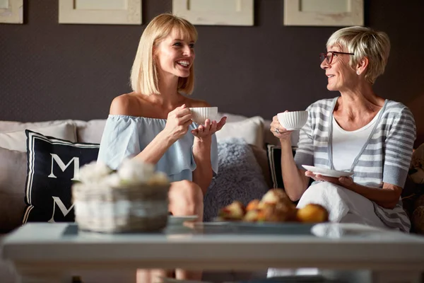 Senior female with young woman drinking coffee — Stock Photo, Image