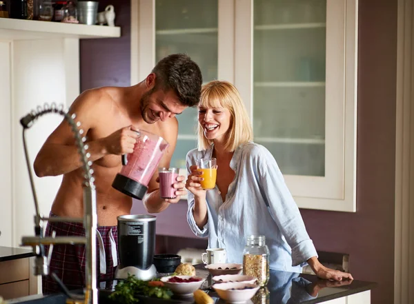 Marido alegre e esposa começando o dia com suco — Fotografia de Stock