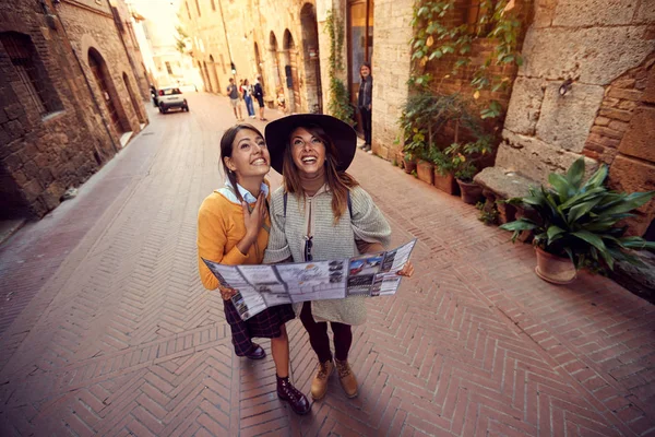 Amigos con mapa en la ciudad — Foto de Stock