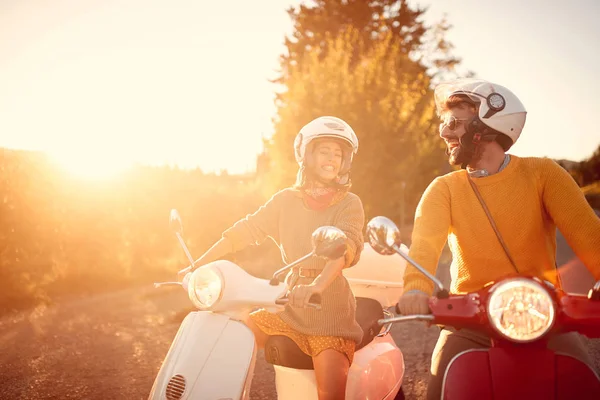 Happy couple riding on a scooter in old European town — Stock Photo, Image