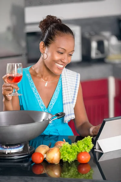 Frau in der Küche nach Rezept auf digitalem Tablet — Stockfoto