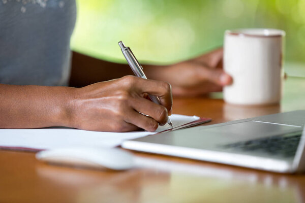 hands of businesswoman with laptop writing