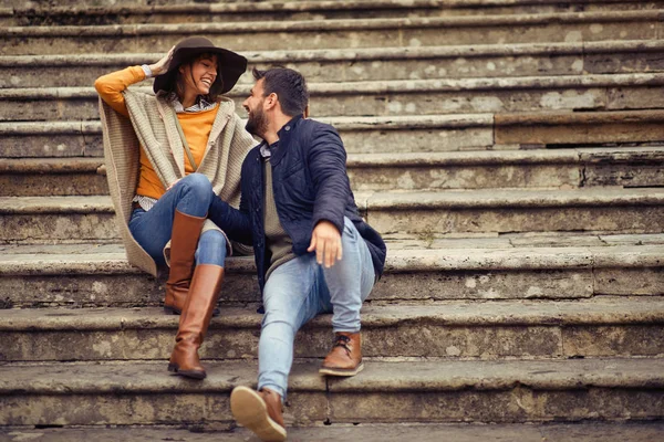 Homme et femme se détendre dans les escaliers tout en profitant en vacances — Photo