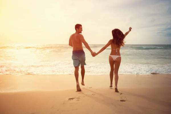 Jovem casal correndo na praia — Fotografia de Stock