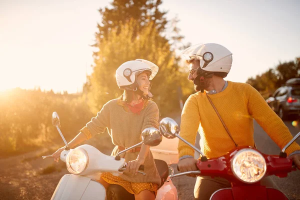 Casal feliz em scooter desfrutando de viagem de carro em férias ao pôr do sol — Fotografia de Stock