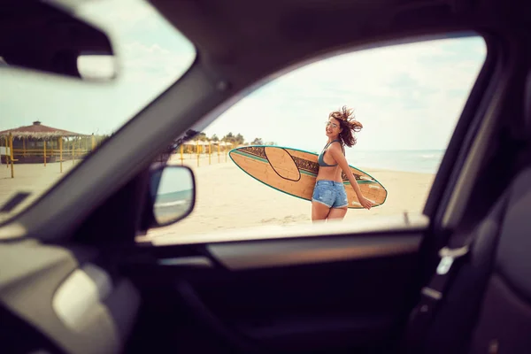 Sorrindo mulher surfista menina em biquíni com prancha de surf andando sobre th — Fotografia de Stock