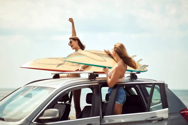 Sexy surfista mulheres por um carro se preparando para surf — Fotografia de Stock