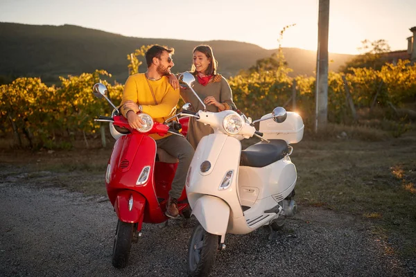 Romantic couple riding on a scooter and enjoying on vacation at sunset — Stock Photo, Image
