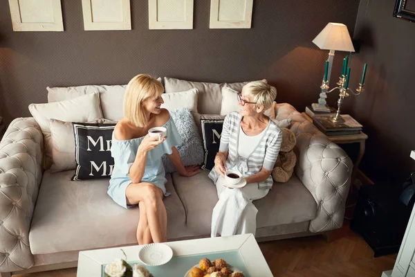 Sala de estar com duas mulheres enquanto bebe café — Fotografia de Stock