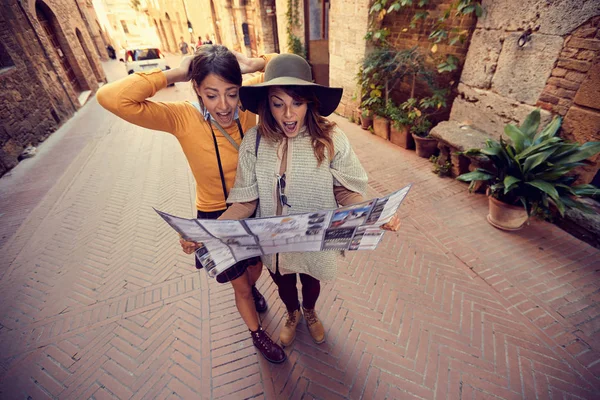 Друзі з картою в місті. Дві дівчини подорожують разом — стокове фото