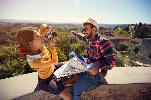 Turista férfi és lány segítségével Térkép útmutató a nyaralás ideje, és figyelembe kép — Stock Fotó