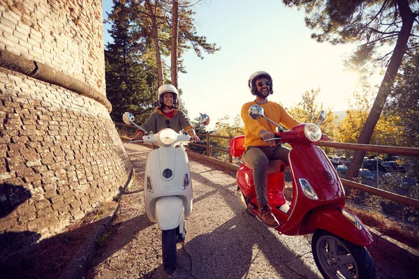 Homem e mulher andando de moto na estrada ao pôr do sol em férias — Fotografia de Stock