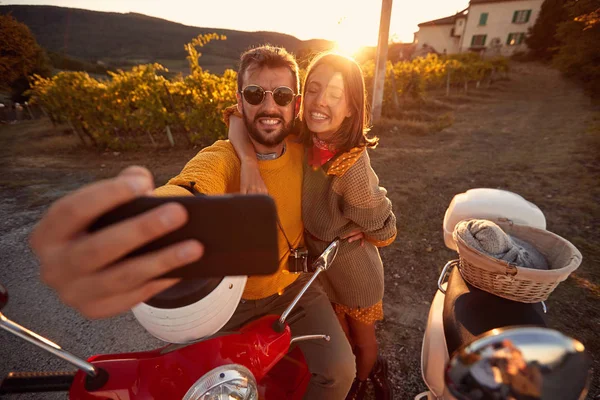 Homem e mulher em viagem romântica em scooter ao pôr do sol em férias — Fotografia de Stock