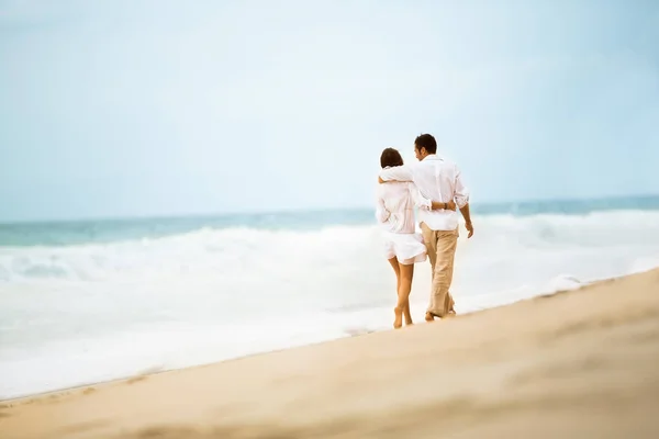 Couple d'amour marchant le long de la plage — Photo