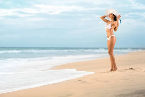 Mujer sexy en bikini de pie en la playa —  Fotos de Stock