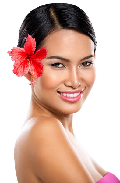 Usměvavá žena s červenou květinou — Stock fotografie