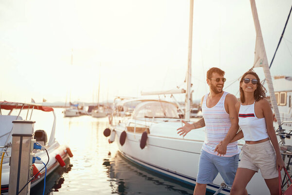 Couple walking near the yachts on the dock
