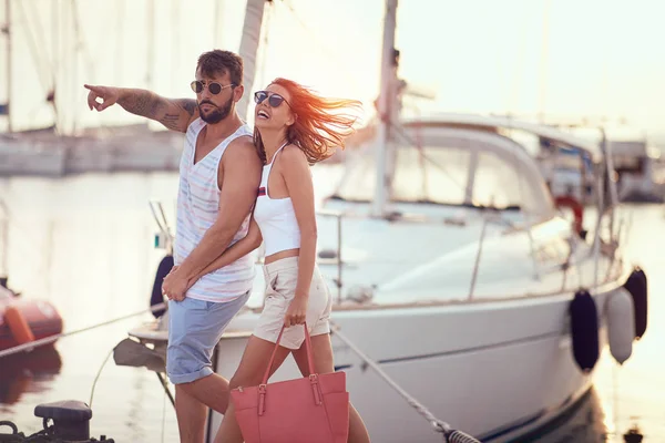 Par i kärlek håller hand njuter av romantiska promenader på bryggan vid solnedgången — Stockfoto