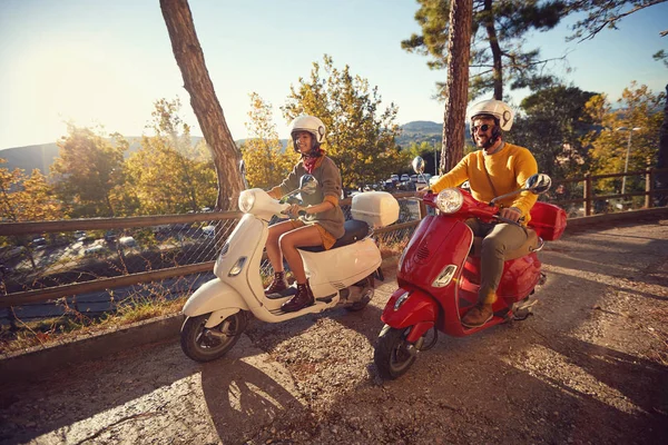 日没時に休暇の旅を楽しんでスクーターの幸せなカップル. — ストック写真