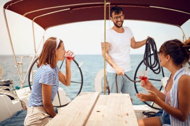 Yelkenli güvertesinde oturan ve eğlenen insanlar. Tatil, seyahat